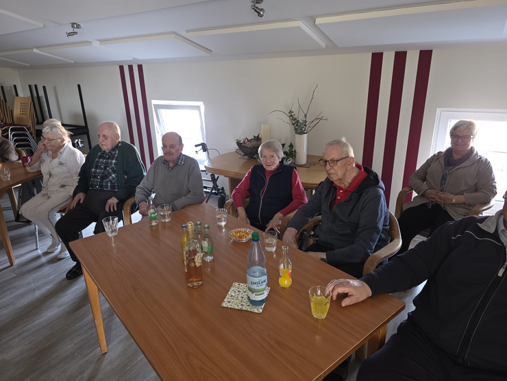 Bewohnerinnen sitzen am Tisch und schauen sich den Film an